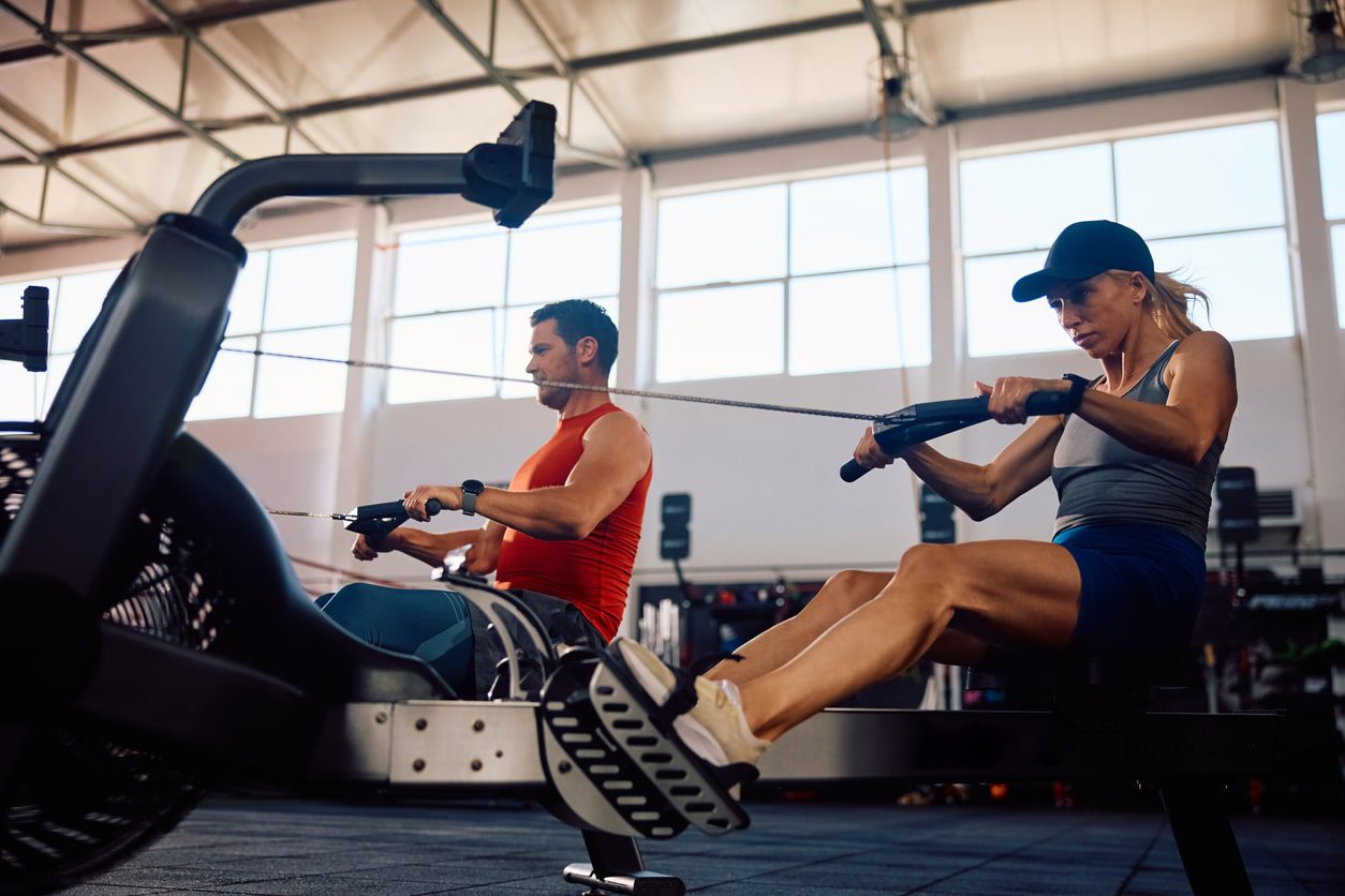 pair on rowing machines in gym